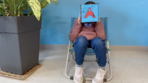 Image tirée du court métrage « Moi ». Une élève tient une boîte sur laquelle est peint la lettre « A » devant son visage. 6. Crédit @ Sophie Boiteau, Svetlana Crudu et leur groupe d'élèves.