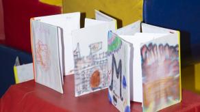 Des livres créés en collaboration avec les élèves sont disposés sur un assemblage de matelas colorés. Crédit photo @ Pénélope et Chloë.